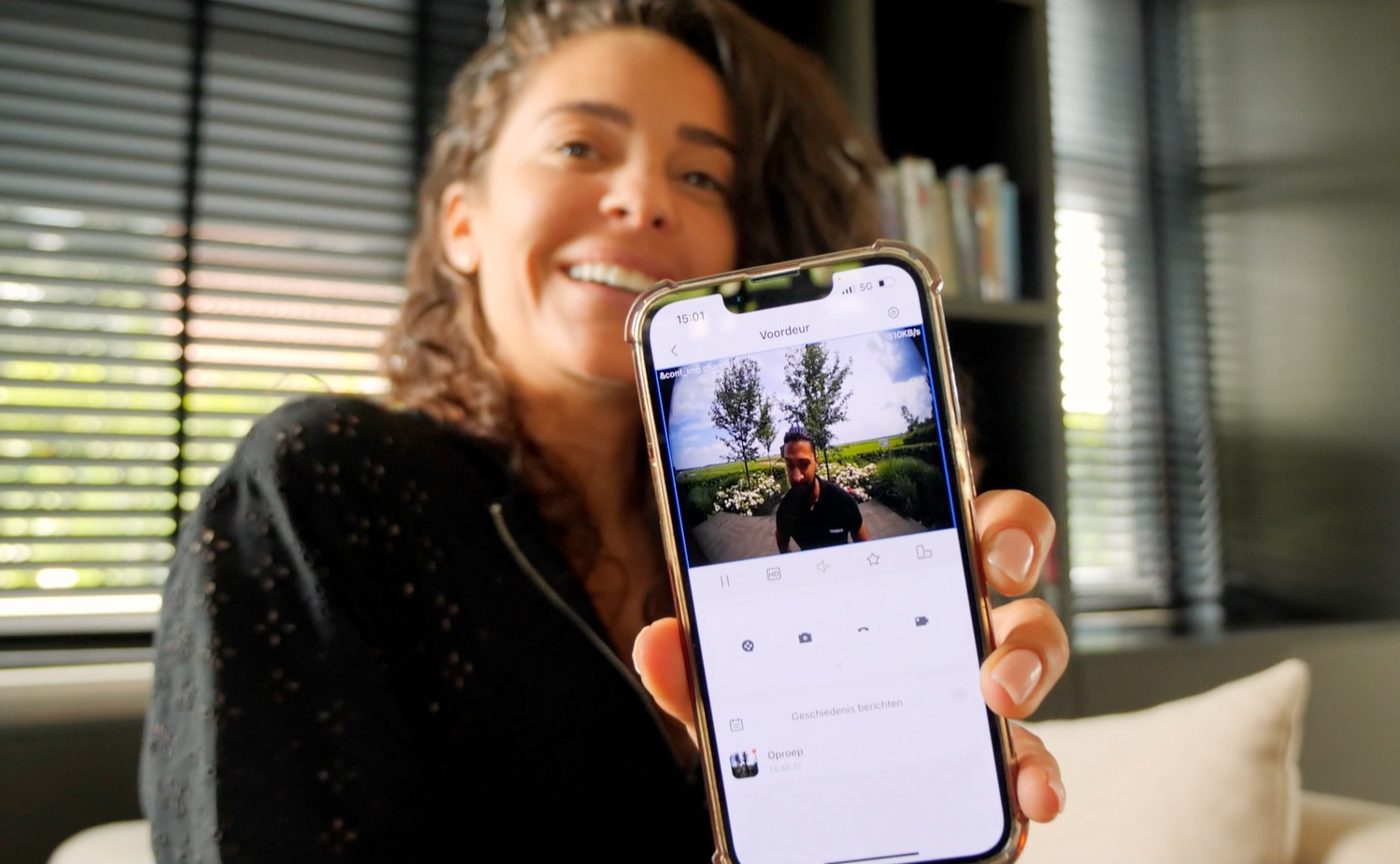 Fajah Lourens laat de camerabeelden van haar woning zien op haar telefoon